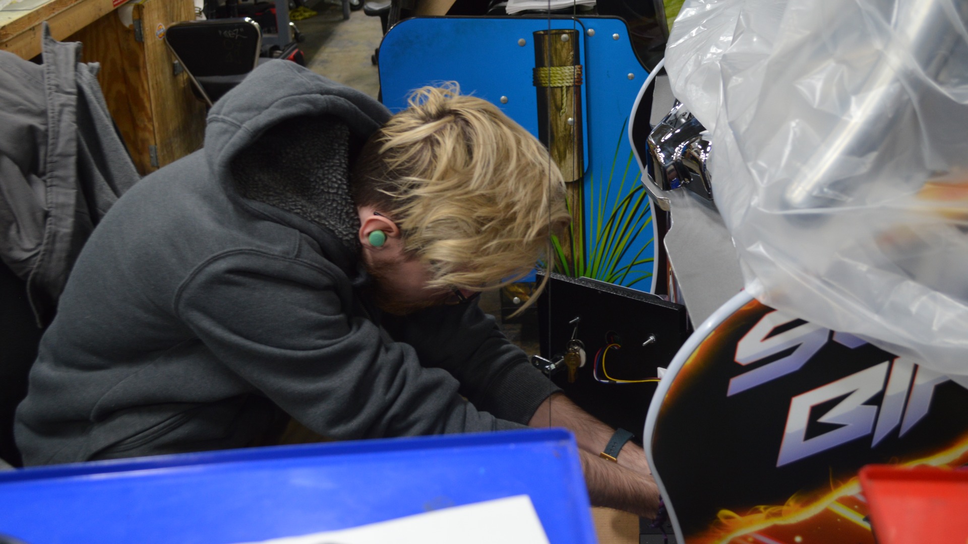man fixing arcade machine